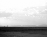 A view across a valley with grave mounds visible. Probably in China, in Kunming province. During WWII.