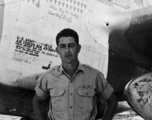 A man poses before the F-5 (a variant of the P-38) 'Mary Ann' piloted by Major H. T. Bailey, who had a crew chief "Snaffy".