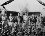 Men from the 21st Photographic Reconnaissance Squadron pose for a group shot in front of an F-5 (a variant of the P-38).