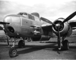 B-25 Mitchell in Yunnan, China, during WWII, with a row of bombs laid out on the ground behind, and bomb  bay doors open.