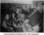 "Hale, Sigmier, Feldman  4th man unknown?" sitting on a jeep at a base in Yunnan province during WWII.