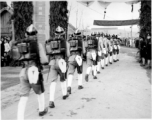 Burma Road dedication parade and ceremony in Kunming, China, on or around February 4, 1945, during WWII. Review of first convoy (or one of the first convoys) to reach China. Chinese soldiers marching in fancy parade dress taking part in elaborate parade.