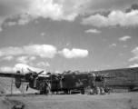 Sichuan (China), B-24 'Doodlebug' being prepared for a mission: "Set in the safety of a reverted hardstand, this B-24 heavy bomber was being readied for a mission. The lady riding a bomb was the trademark of this aircraft named 'Doodlebug' by its crew members. The row of bombs indicate missions carried out. The small Japanese flags represent enemy aircraft shot down. This is an early model plane. Later model B-24's were equipped with a nose gun turret. The turrets provided better target coverage and firepow