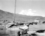 A wooden boat and stone tower at Xiaguan Township (下关), in western Yunnan province, along the route of the Burma Road, and at the outlet of Erhai Lake (洱海). During WWII.