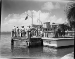 A GIs and civilians play at the waterside, likely in Florida, during WWII. Note U. S. Army boats #J-2361 & #T-171.