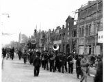 A funeral procession in China during WWII, with musicians and mourners. The large placard being carried says 福寿无疆, something like Limitless Good Life.