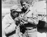 At the Tengchong cutoff: Convoy driver S/Sgt. Michale P. Havery, is shown lighting up cigarette of a Chinese soldier.  Yunnan Province on March 4, 1945.  Photo by T/Sgt. Greenberg.  Passed by William E. Whitten.