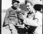 At the Tengchong cutoff: Convoy driver Pfc. John R. Floyd shows a kids a picture of his wife.  Yunnan Province on March 4, 1945.  Photo by T/Sgt. Greenberg.  Passed by William E. Whitten.