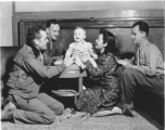  T/Sgt. Franklin E. Ditto, Sgt. Raymond F. Brunner, ARC civilian aide Lucy, and Cpl. Theodore A. Kobel play with Virginia Elizabeth Porter. Yunnan Province on December 15, 1944.   Photo by Pfc. Thomas F. Melvin.  Passed by Emanuel Goldberg.