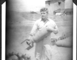 Sam Hansen holds a bomb, probably near Chenggong air base, Yunnan, China. During WWII.