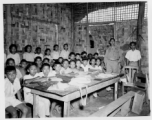 Local people in Burma near the 797th Engineer Forestry Company--GI visits a local school (very likely a missionary school, given the materials in the classroom and the clothing the kids are wearing) in Burma.  During WWII.