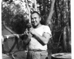 Irwin W. Hayden of the 2005th Ordnance Maintenance Company,  28th Air Depot Group, holds gang mascot, the dog "Evan."