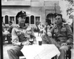 Dave Hayward and Jim Hamer drink "Vimto" (British soft drink) at a sidewalk cafe in Agra. 22nd Bombardment Squadron, during WWII.