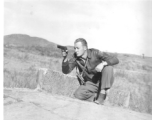 Flyer Ted Simmons playing with pistol on stone bridge at Chanyi (Zhanyi), during WWII.