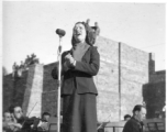 Opera singer Lilly Pons sings at a USO show in Gushkara, India, during WWII.  The boxes in front of the band players are labeled 748th ROB (748th Railway Operating Battalion).