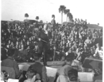 Conductor Andre Kostelanetz directs at a USO show in Gushkara, India, during WWII.  The boxes in front of the band players are labeled 748th ROB (748th Railway Operating Battalion).