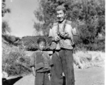 Chinese boy and man at Chanyi (Zhanyi), during WWII, at mealtime.