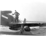 A flyer with a P-51 Mustang fighter, probably at an American air base in China. During WWII.  This appears to be Ernest W. Garner.