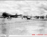 Runway with workers, hand-pulled roller, and airplanes in busy profusion, on the US base at Liuzhou, Guangxi province, China, in 1945.