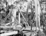 Friend of Bob Riese poses amongst remains of aircraft factory and hangers at the air base at Liuzhou, in 1945. The facilities at the base were first destroyed by the Chinese and Americans during retreat in the face of Ichigo during the fall of 1944, then may have been destroyed more by American bombardment during Japanese occupation, and possibly destroyed more by the Japanese as they retreated the area in 1945.