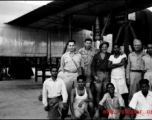 American and Indian service crew members pose for the camera in front of a B-24 up on jack and undergoing maintenance. 61st Air Service Group.