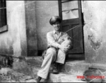 An American serviceman, presumably a member of the  27th Troop Carrier Squadron, sits on a step in the CBI during WWII.