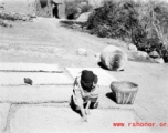 A woman drying grain in a village in Yunnan province, China. During WWII.