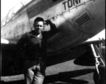 An American serviceman stands next to a P-51 fighter named "Toni".