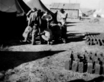 A handful of GIs huddle at a tent city at a base near "Kunming, China" during WWII.