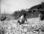 A worker crushing rock by hand at a base in southwest China, during WWII.