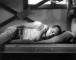 Barracks life at an American base in southwest China during WWII: GI lies pensively on his bunk. 