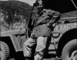 16th Combat Camera Unit photographer Hal Geer leans against jeep as he poses in Liuzhou in 1945.