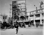 A GI walks on a Kunming street with slogans about Chiang Kai-shek in the background, and an image of British politician Clement Richard Attlee.