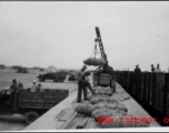 GIs moving aerial bombs between trucks and train in the CBI during WWII.