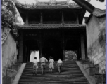 A well-off Chinese family climbs steps to a temple in the CBI during WWII.