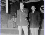 A GI holds the microphone as musicians wait, in the CBI during WWII. 322nd Troop Carrier.