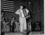 A GI plays accordian, while the "Jive-o-Lieps" of the 54th Air Service Group wait their turn In the CBI during WWII.