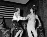 GIs perform at the microphone while musicians of the "Jive-o-Lieps" of the 54th Air Service Group watch on. In the CBI during WWII.