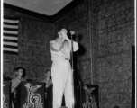 A GI plays harmonica as part of performance, while the band Jive-o-Lieps waits their turn. 54th Air Service Group.