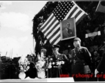 Burma Road dedication ceremony in Kunming, China, on February 4, 1945, during WWII. Review of first convoy (or one of the first convoys) to reach China. General view of the stage and reviewing party, with American and Chinese dignitaries, soldiers, and civilian VIPs. An American band plays, and an honor lines on both sides of the center carpet stand in formation.  Official dignitaries at the ceremony included, on the Chinese side, such figures as General Lung Yun, Governor of Yunnan Province,  Gen. Wang Yu-