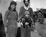 A couple with their young baby boy, probably at Yangkai (Yangjie), in Yunnan province.