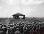 Chinese soldiers standing around a stage during a ceremony in southern China, probably Yunnan province, or possibly in Burma.