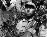 Chinese soldiers with equipment ready and covered in camouflage during exercises in southern China, in Yunnan province, including this Nationalist soldier with rifle over shoulder.