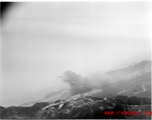 Smoke arises in the distance after an American attack on Hong Kong harbor during WWII.