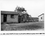 Workers fill water tank at an American base in Yunnan, China, during WWII.  GIs sitting on wooden platform.