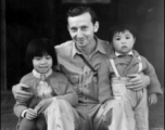 Eugene Wozniak, a combat photographer who served in the CBI, as part of the 491st Bomb Squadron, with two Chinese children during WWII.