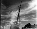 Boat 'Icaros" ground on the sandy shore in India.  Scenes in India witnessed by American GIs during WWII. For many Americans of that era, with their limited experience traveling, the everyday sights and sounds overseas were new, intriguing, and photo worthy.