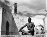 Man sitting cross-legged in India in 1943.  Scenes in India witnessed by American GIs during WWII. For many Americans of that era, with their limited experience traveling, the everyday sights and sounds overseas were new, intriguing, and photo worthy.