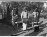 Men with cymbal, drum, and person in a dress.  Scenes in India witnessed by American GIs during WWII. For many Americans of that era, with their limited experience traveling, the everyday sights and sounds overseas were new, intriguing, and photo worthy.