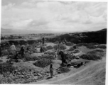 People crush rocks by hand.  Scenes in India witnessed by American GIs during WWII. For many Americans of that era, with their limited experience traveling, the everyday sights and sounds overseas were new, intriguing, and photo worthy.